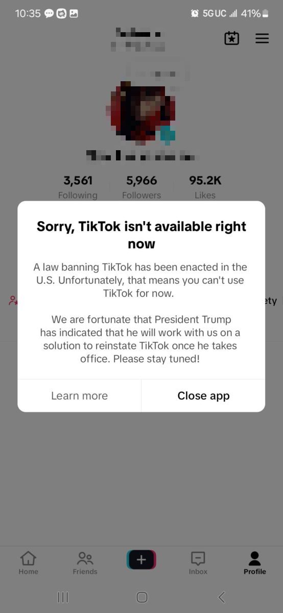A phone screenshot of a TikTok profile covered by a message: Sorry, TikTok isn't available right now. A law banning TikTok has been enacted in the U.S.